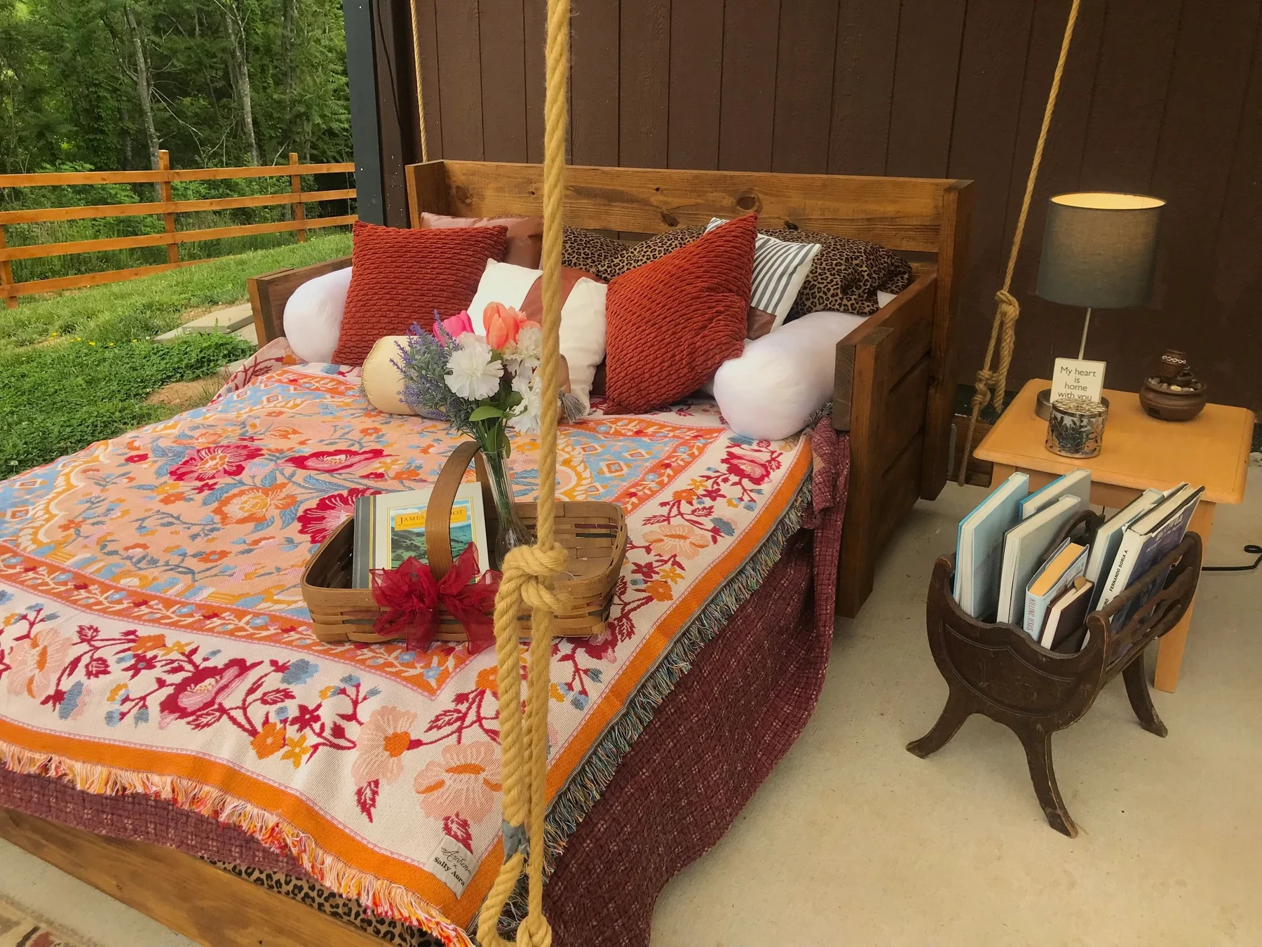 The handmade daybed swing with colorful cushions in the rustic pavilion