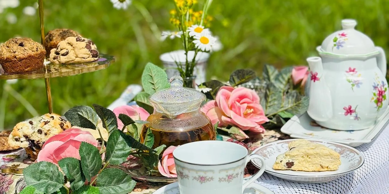 Floral china, tea and pastries set out for an outdoor tea party